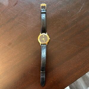 Authentic ladies Movado watch in gold with black leather band.